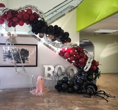 Spooky Staircase Display with Balloon Garland, Skeleton Accents & “BOO” Marquee Lights