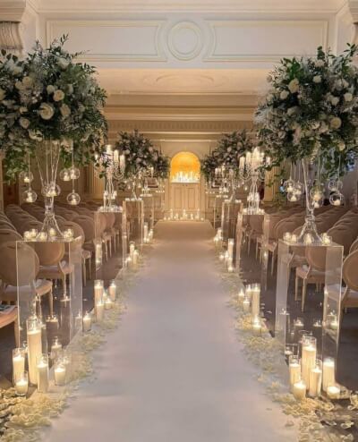 Romantic Candlelit Aisle with White Floral Arrangements, Trumpet Vases & Clear Pedestal Pillars