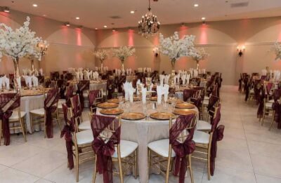Regal Burgundy & Gold Reception with Sheer Chair Sashes, Gold Chargers & Tall Floral Centerpieces
