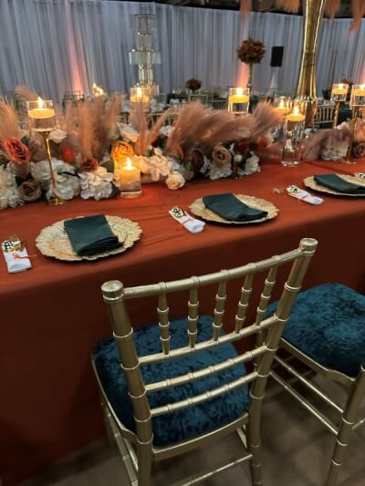 Warm Autumn-Inspired Table Setting with Terracotta Linens, Floating Candles, Dried Pampas & Florals